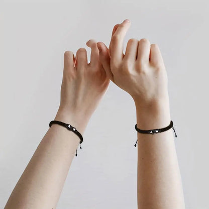 Photo of 2 hands wearing an initial of your choice braided black bracelet - JustJewelry