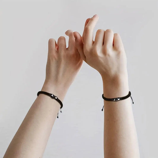 Photo of 2 hands wearing an initial of your choice braided black bracelet - JustJewelry